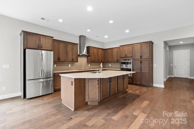 253 Stone Mountain Way, Denver, NC 28037 - kitchen with appliances with stainless steel finishes, wall chimney range hood, decorative backsplash, a center island with sink, and recessed lighting
