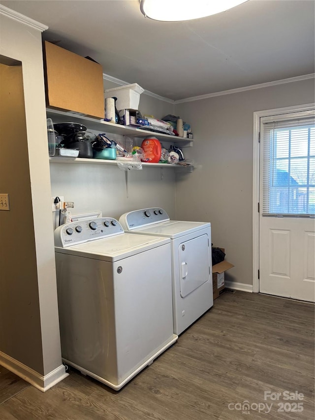 laundry room with washing machine and dryer, crown molding, and dark wood-type flooring