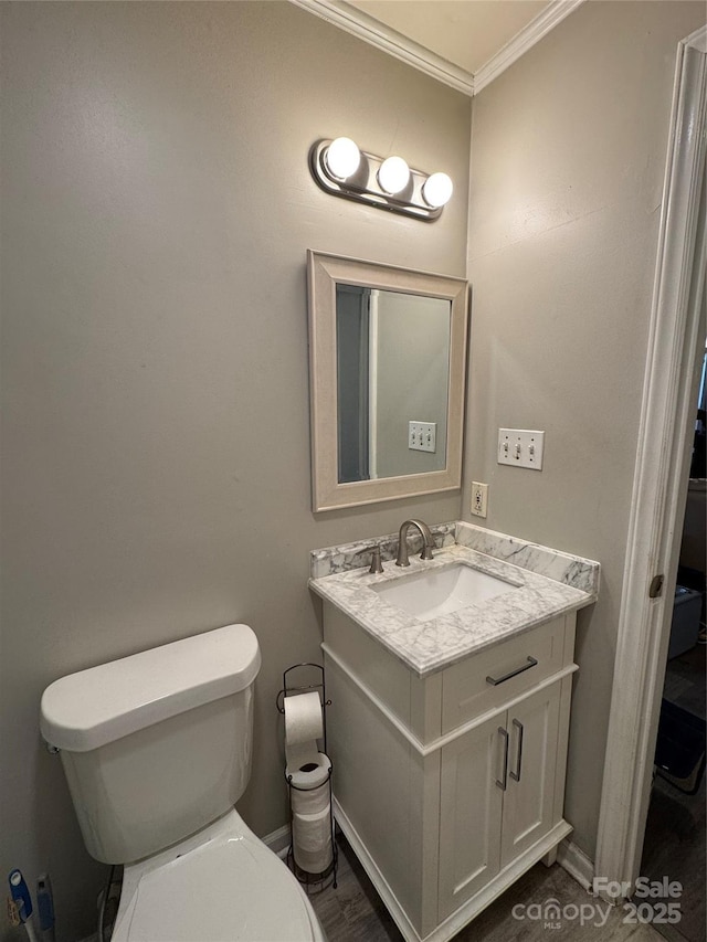 bathroom with vanity, toilet, and crown molding