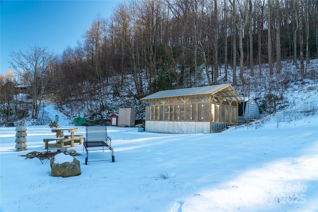 yard layered in snow with a sunroom