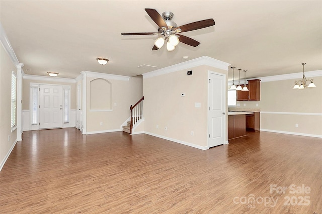 unfurnished living room featuring hardwood / wood-style floors, ceiling fan with notable chandelier, and ornamental molding