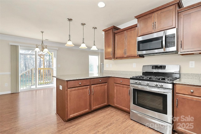 kitchen with stainless steel appliances, light stone counters, a notable chandelier, kitchen peninsula, and pendant lighting