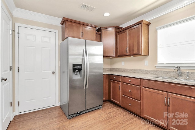 kitchen featuring light wood-type flooring, light stone counters, crown molding, sink, and stainless steel fridge with ice dispenser