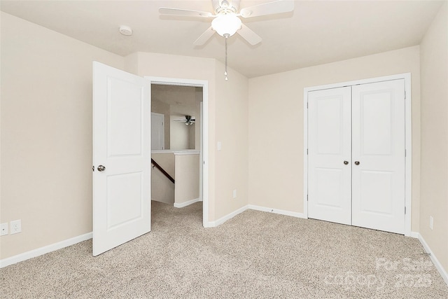 unfurnished bedroom with a closet, light colored carpet, and ceiling fan