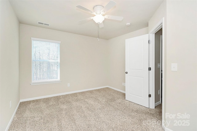 empty room with ceiling fan and light carpet