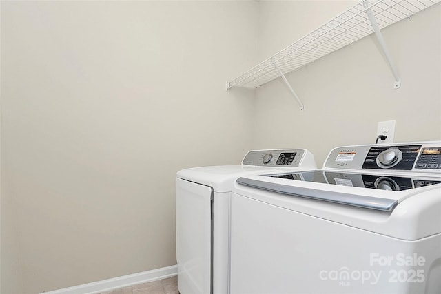 laundry area featuring washer and clothes dryer and light tile patterned floors