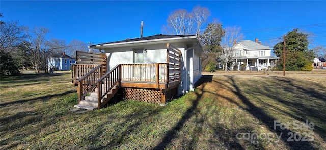 rear view of house featuring a deck and a lawn