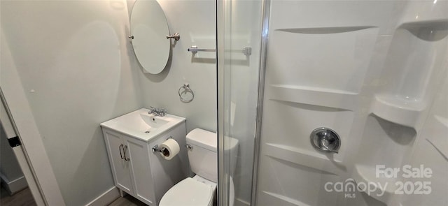 bathroom with a shower, vanity, and toilet