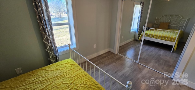 unfurnished bedroom featuring multiple windows and dark wood-type flooring