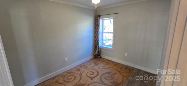 spare room with hardwood / wood-style floors and crown molding