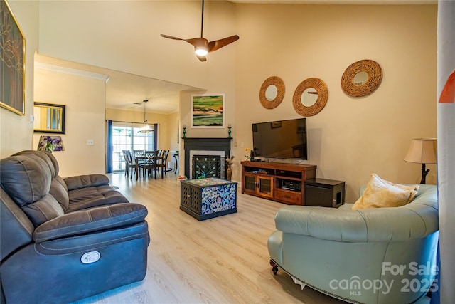 living room with hardwood / wood-style floors, ceiling fan, and crown molding