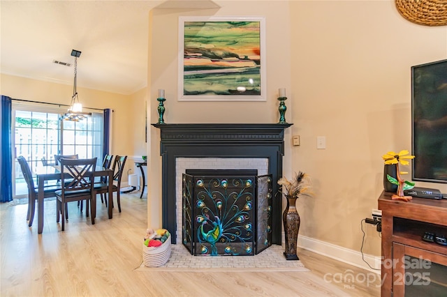 living room featuring crown molding and light hardwood / wood-style flooring