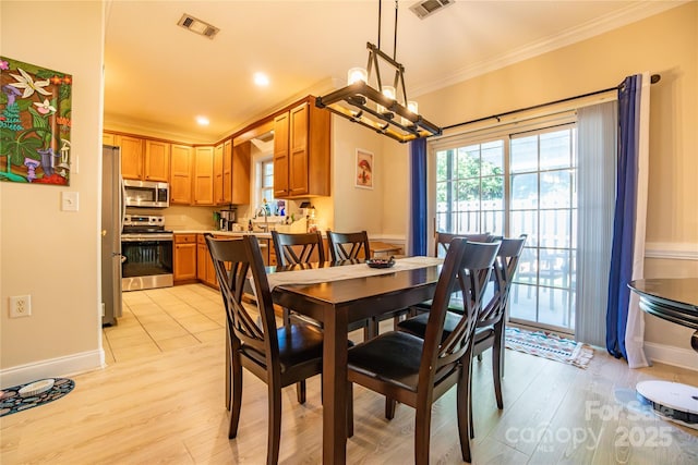 dining space featuring light hardwood / wood-style floors and crown molding