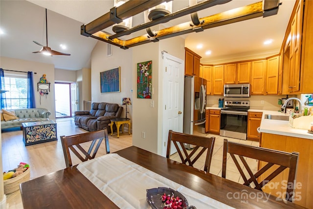 dining space with ceiling fan, light hardwood / wood-style floors, and sink