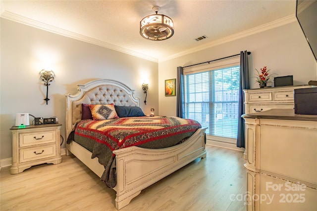 bedroom featuring a textured ceiling, light hardwood / wood-style flooring, and ornamental molding