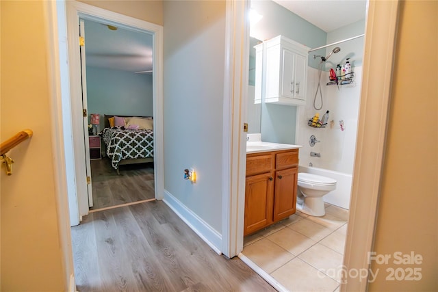 full bathroom with washtub / shower combination, hardwood / wood-style floors, vanity, and toilet