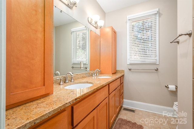 bathroom with tile patterned floors, plenty of natural light, vanity, and toilet