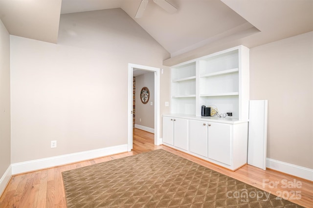 empty room featuring ceiling fan, light hardwood / wood-style flooring, and vaulted ceiling