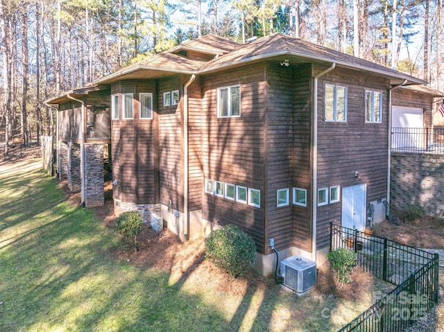 view of side of home featuring a yard and central AC unit