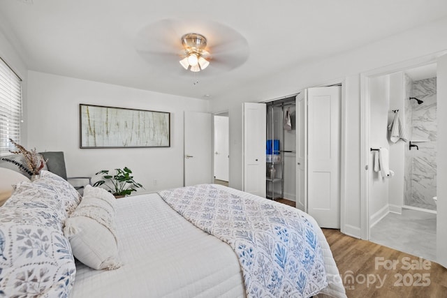 bedroom with ensuite bathroom, ceiling fan, and hardwood / wood-style flooring