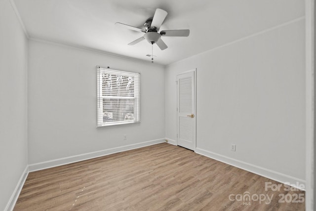 empty room with ceiling fan, light wood-type flooring, and ornamental molding