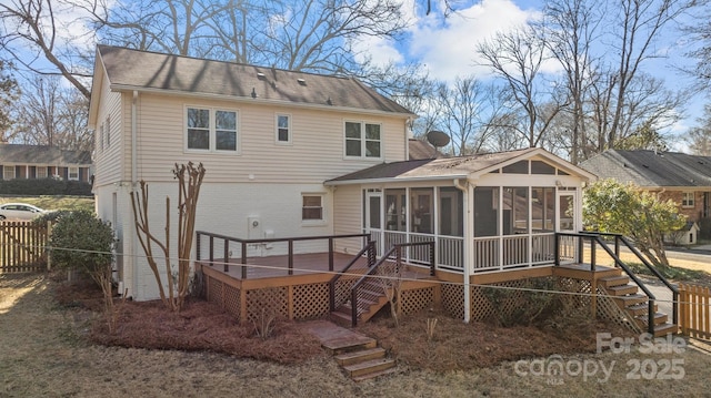 rear view of property with a sunroom and a deck