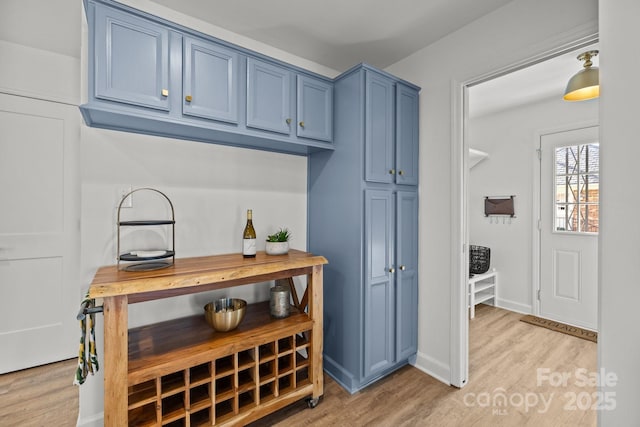 interior space with light hardwood / wood-style floors and blue cabinets