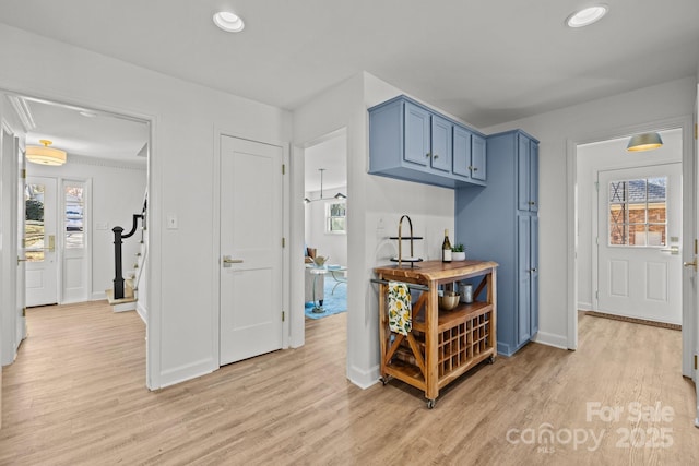 kitchen with blue cabinetry, light hardwood / wood-style flooring, and a healthy amount of sunlight