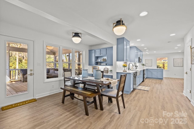 dining space featuring light wood-type flooring and sink