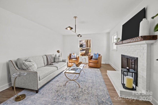 living room featuring hardwood / wood-style flooring and a brick fireplace