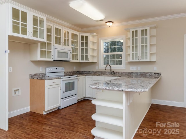 kitchen with white appliances, dark wood-type flooring, white cabinets, light stone countertops, and kitchen peninsula