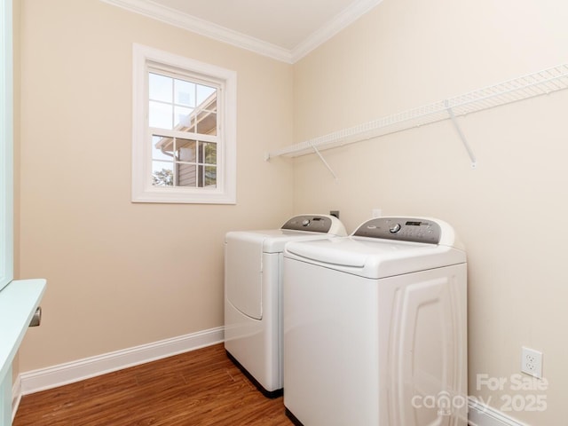 washroom featuring washing machine and dryer, crown molding, and hardwood / wood-style flooring