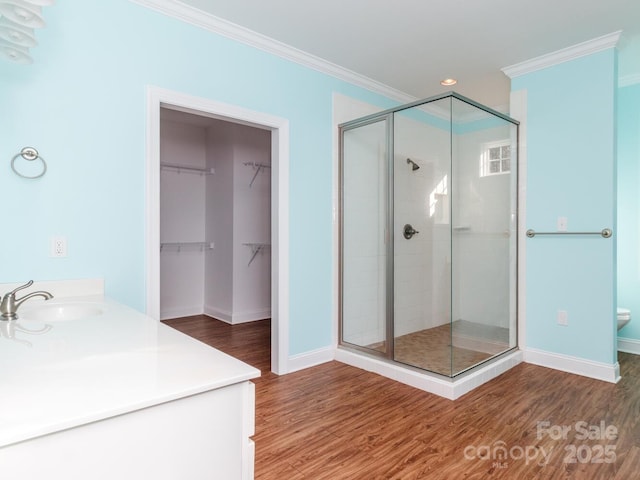 bathroom with crown molding, an enclosed shower, and hardwood / wood-style flooring