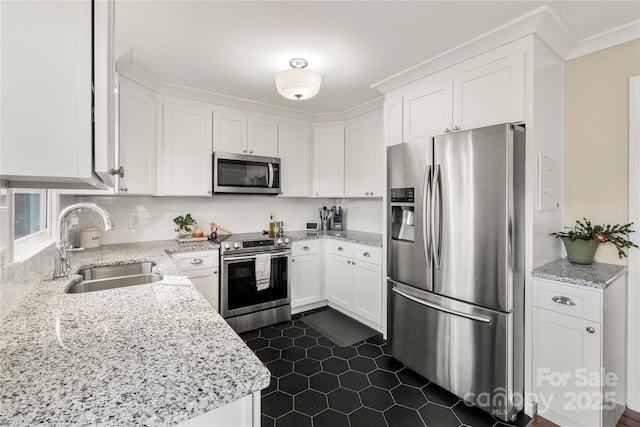 kitchen with white cabinets, sink, light stone countertops, and stainless steel appliances