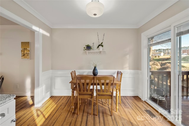 dining space featuring light hardwood / wood-style floors and ornamental molding