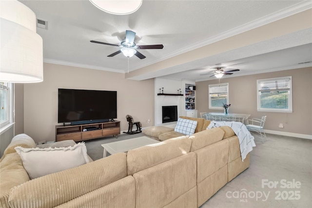 carpeted living room featuring ceiling fan, ornamental molding, and a fireplace