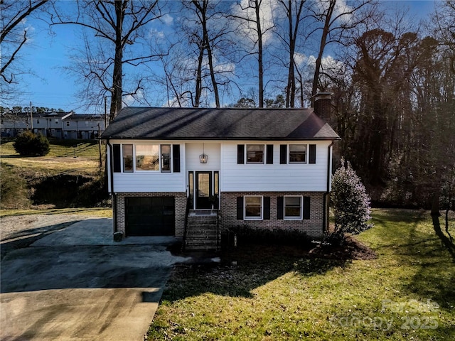 bi-level home with a garage and a front lawn