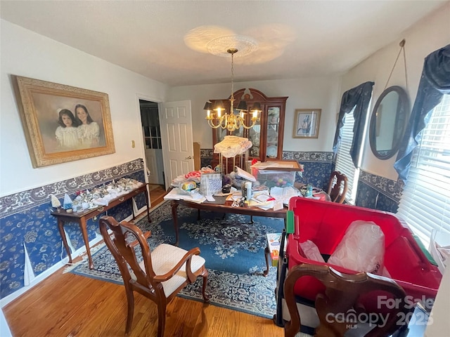 dining area featuring hardwood / wood-style flooring and a chandelier