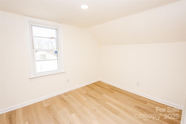 additional living space with vaulted ceiling and wood-type flooring