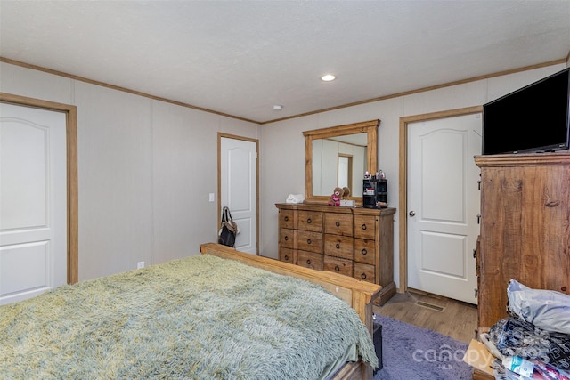 bedroom with light hardwood / wood-style flooring and ornamental molding