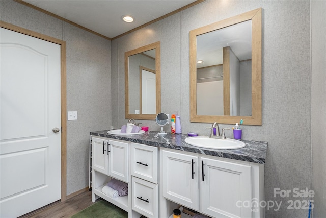 bathroom featuring wood-type flooring, vanity, and crown molding