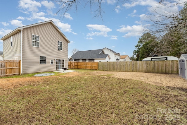 rear view of property with a yard, a shed, and a patio area