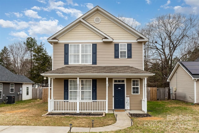 front facade featuring covered porch, central air condition unit, and a front lawn