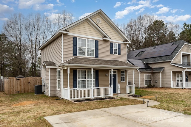 view of property with solar panels, a porch, a front yard, and central AC