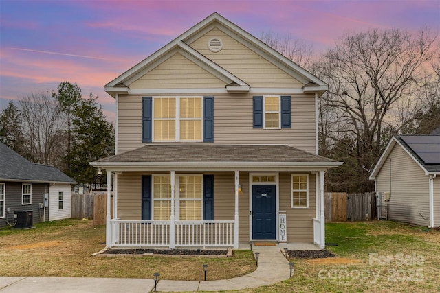 front of property with a lawn, a porch, and cooling unit