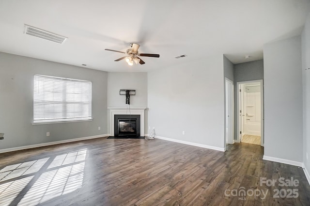 unfurnished living room with ceiling fan and dark wood-type flooring