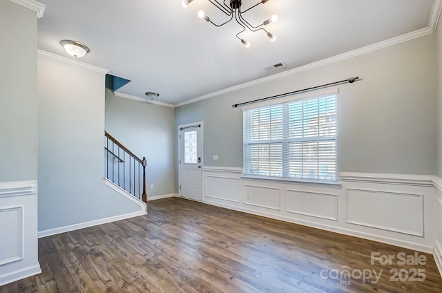 foyer with a chandelier, dark hardwood / wood-style flooring, and crown molding