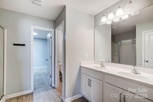 bathroom featuring vanity, hardwood / wood-style flooring, toilet, and walk in shower