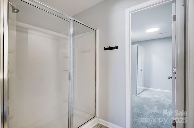 bathroom featuring a shower with door