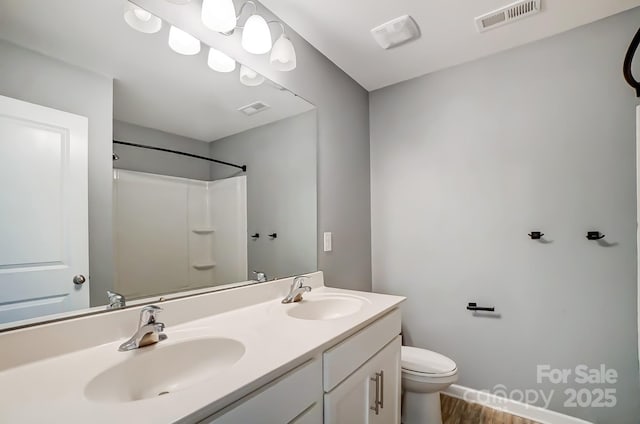 bathroom featuring vanity, toilet, wood-type flooring, and a shower